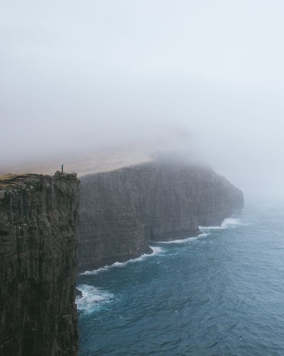 Sea cliffs disappearing into thick fog